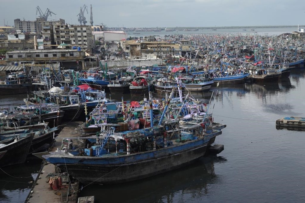 Fishing boats are anchored at a fishing harbor after weather forecasters warned fishermen not to venture out to sea following a tropical storm developing in the Arabian sea in Karachi, Pakistan, Friday, Aug. 30, 2024. (AP Photo/Fareed Khan)