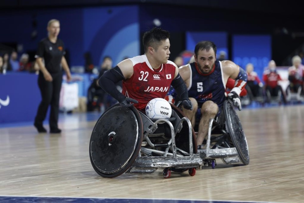 Japan's Katsuya Hashimoto, left, looks to score during the U.S. vs Japan preliminary match of wheelchair rugby, at the Paralympic Games in Paris, Friday, Aug. 30, 2024. Japan won 45-42. (AP Photo/Avni Trivedi)