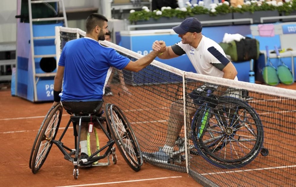 Israel's Adam Berdichevsky, right, and Italy's Luca Arca shake hands after their 2024 Paralympics men's Wheelchair singles tennis tournament first round match at Roland Garros Stadium in Paris, France, Friday Aug. 30, 2024. (AP Photo/Michel Euler)