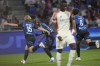 Strasbourg's Sebastian Nanasi, left, celebrates after scoring his side's opening goal during the French League One soccer match between Lyon and Strasbourg at the Groupama stadium in Decines, outside Lyon, France, Friday, Aug. 30, 2024. (AP Photo/Laurent Cipriani)