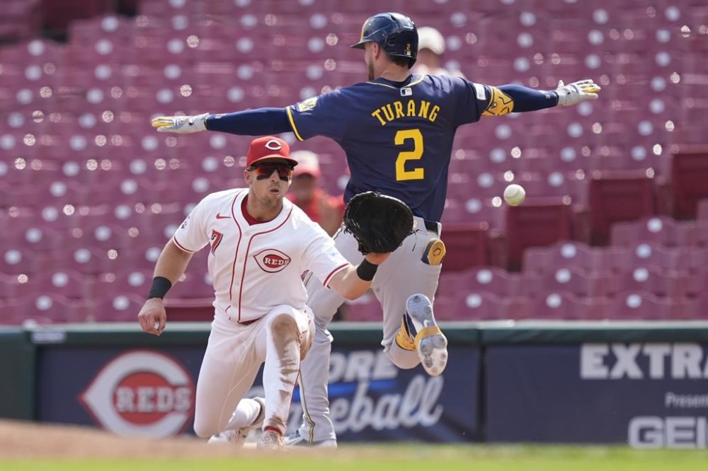 Milwaukee Brewers' Brice Turang is safe at first as Cincinnati Reds' Spencer Steer takes the throw during the tenth inning of a baseball game, Friday, Aug. 30, 2024, in Cincinnati. The Brewers won 5-4 in ten innings. (AP Photo/Carolyn Kaster)