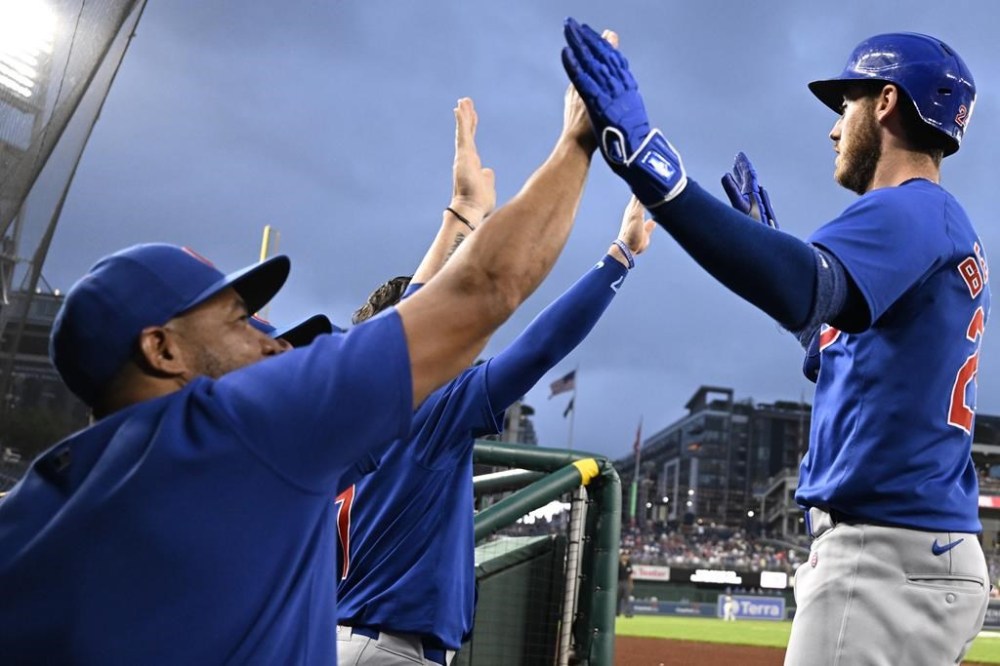 Chicago Cubs' Cody Bollinger, right, is greeted in the dugout after hitting a two-run home run during the inning of a baseball game against the Washington Nationals, Friday, Aug. 30, 2024, in Washington. (AP Photo/John McDonnell)