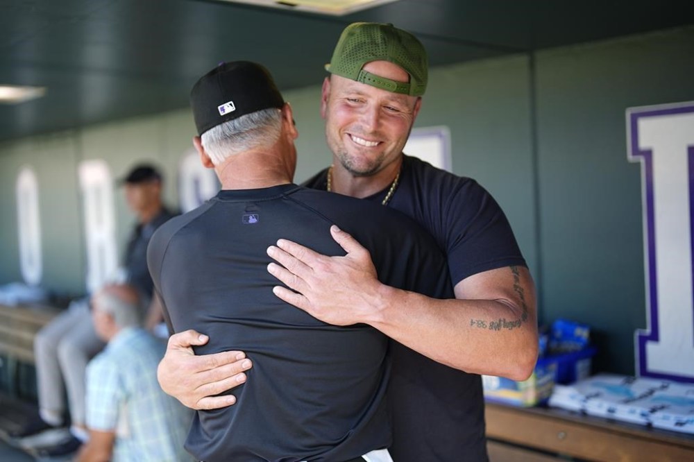 Retired Major League Baseball player Matt Holliday greets Colorado Rockies manager Bud Black before the Baltimore Orioles face the Rockies in a baseball game, Friday, Aug. 30, 2024, in Denver. (AP Photo/David Zalubowski)