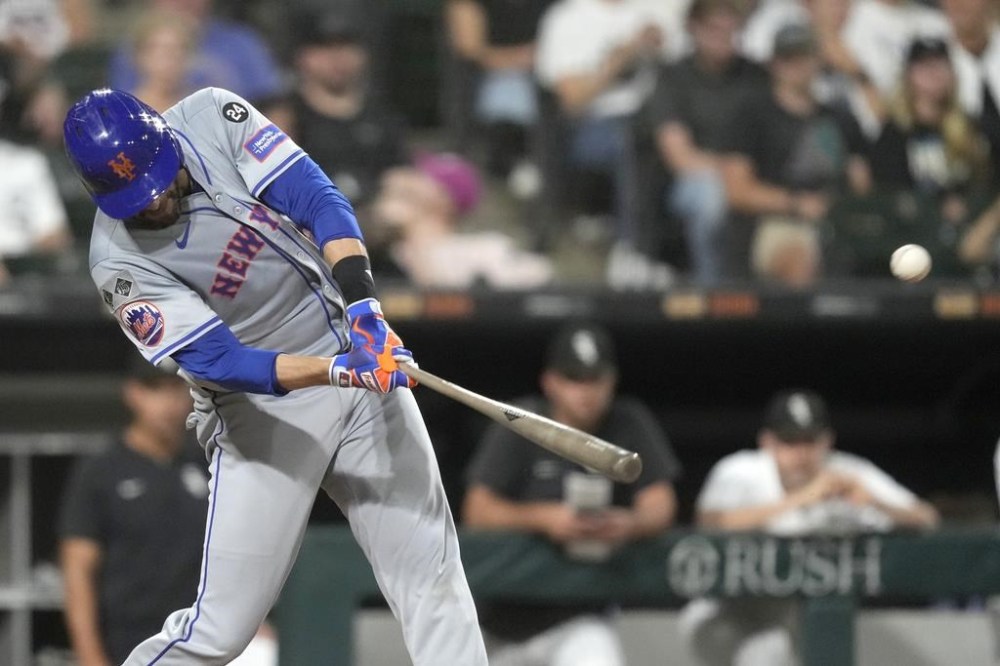 New York Mets' J.D. Martinez hits a two-run home run off Chicago White Sox pitcher Jonathan Cannon, also scoring Jesse Winker, during the third inning of a baseball game Friday, Aug. 30, 2024, in Chicago. (AP Photo/Charles Rex Arbogast)
