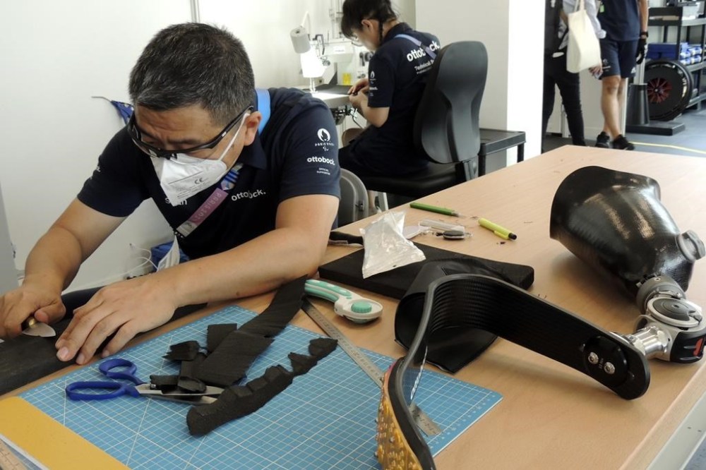 An Ottobock employee works in the Ottobock repair center at the Paralympic Village in Saint-Denis, near Paris, France, Saturday, Aug. 24, 2024. (AP Photo/Tom Nouvian)
