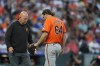 Baltimore Orioles starting pitcher Dean Kremer, right, has his arm checked by a trainer after being hit by a ground ball off the bat of Colorado Rockies' Jordan Beck in the fourth inning of a baseball game Saturday, Aug. 31, 2024, in Denver. (AP Photo/David Zalubowski)