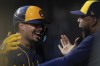 Milwaukee Brewers' Willy Adames, left, celebrates in the dugout after hitting a three-run home run during the third inning of a baseball game against the Cincinnati Reds, Saturday, Aug. 31, 2024, in Cincinnati. (AP Photo/Carolyn Kaster)
