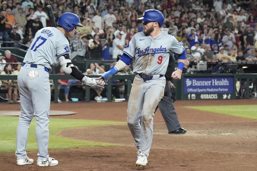 Los Angeles Dodgers' Gavin Lux (9) celebrates his run scored against against the Arizona Diamondbacks with Dodgers' Shohei Ohtani (17), of Japan, during the ninth inning of a baseball game Saturday, Aug. 31, 2024, in Phoenix. (AP Photo/Ross D. Franklin)