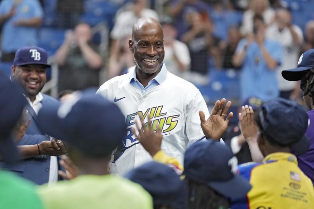 Former Tampa Bay Rays player Fred McGriff, center, high fives members of the Boys and Girls Club of Tampa Bay before being inducted into the Rays Hall of Fame before a baseball game between the Rays and the San Diego Padres Sunday, Sept. 1, 2024, in St. Petersburg, Fla. (AP Photo/Chris O'Meara)