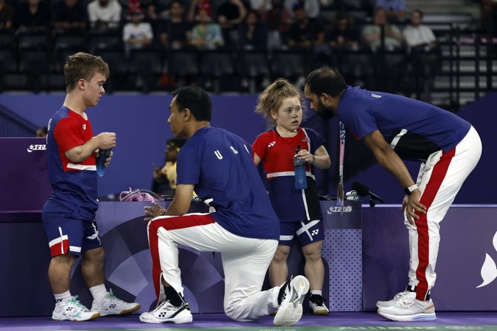 U.S. Para Badminton coaches, Moss Lattison and Abhishek Ahlawat, right, talk to Miles Krajewski, left, and Jayci Simon in between sets of the mixed doubles SH6 gold medal match against Naili Lin and Fengmei Li, from China, during the Paralympic Games in Paris on Monday, Sept. 2, 2024. China won the match in straight sets/ (AP Photo/Avni Trivedi)
