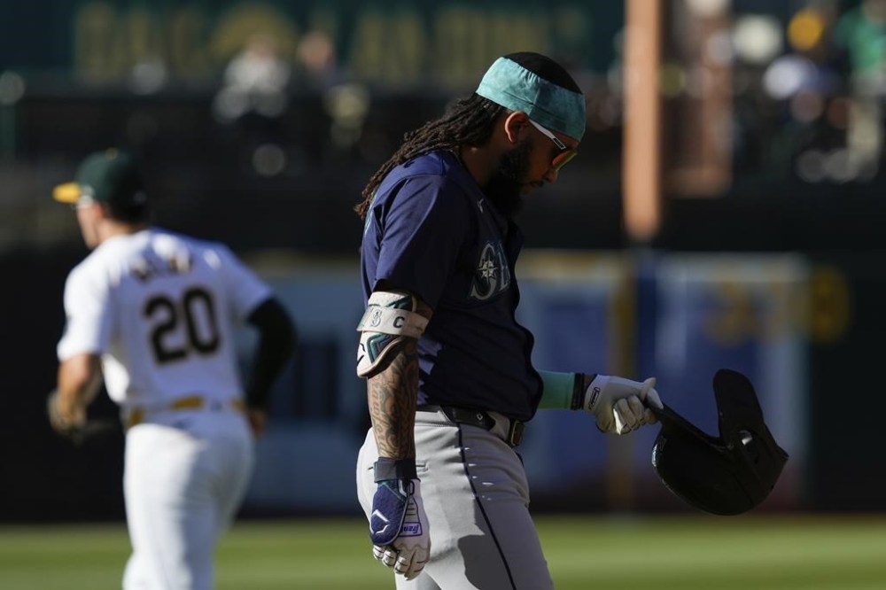 Seattle Mariners' J.P. Crawford, right, reacts after hitting a ground ball to Oakland Athletics first baseman Tyler Nevin for an out during the fifth inning of a baseball game Monday, Sept. 2, 2024, in Oakland, Calif. (AP Photo/Godofredo A. Vásquez)