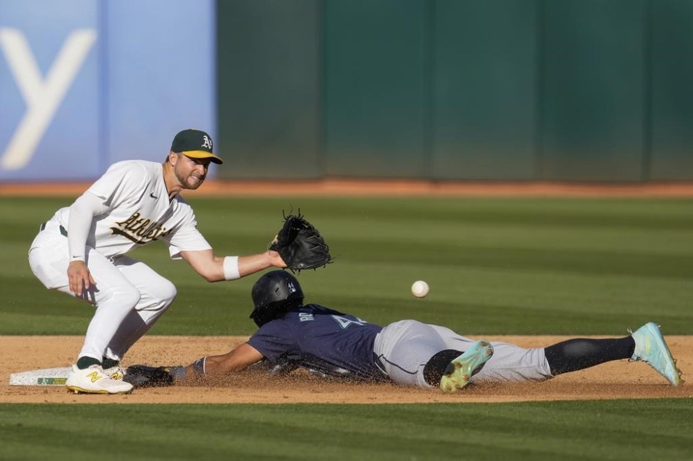 Seattle Mariners' Julio Rodríguez, right, steals second next to Oakland Athletics shortstop Max Schuemann, left, during the sixth inning of a baseball game Monday, Sept. 2, 2024, in Oakland, Calif. (AP Photo/Godofredo A. Vásquez)
