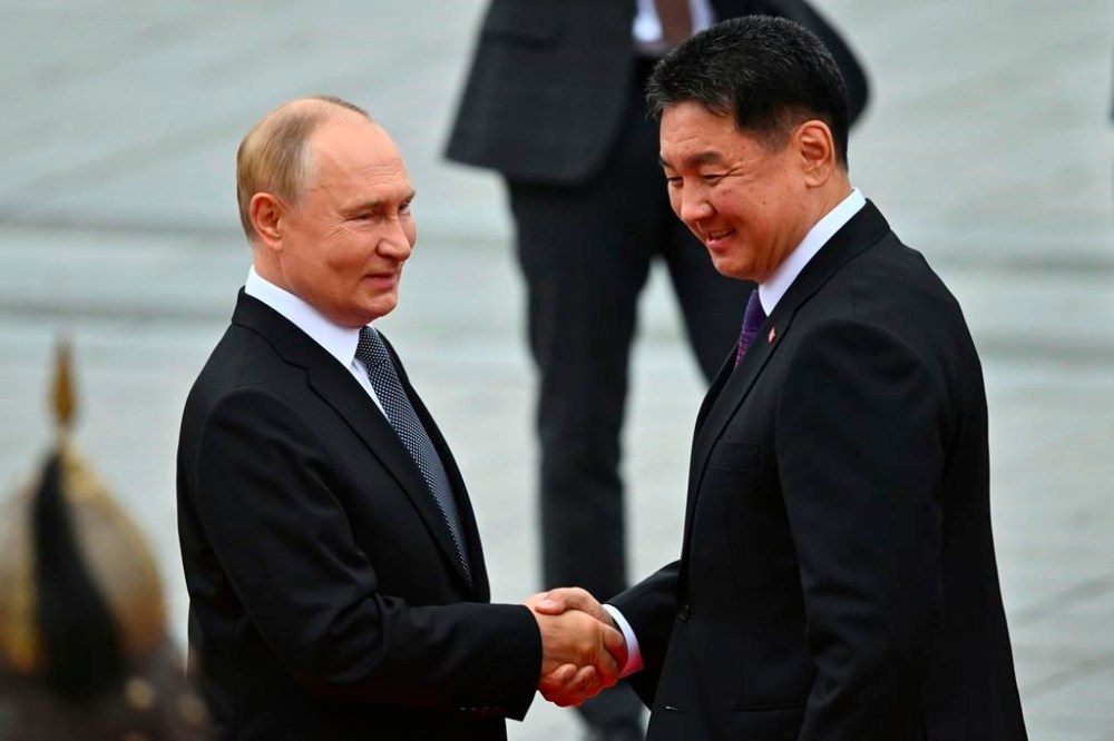 Russian President Vladimir Putin, left, and Mongolian President Ukhnaagiin Khurelsukh shake hands during a welcoming ceremony at Sukhbaatar Square in Ulaanbaatar, Mongolia, Tuesday, Sept. 3, 2024. (Kristina Kormilitsyna, Sputnik, Kremlin Pool Photo via AP)