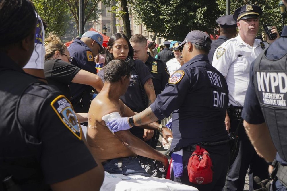 First responders tend to a man injured during a shooting at the West Indian Parade, Monday, Sept. 2, 2024, in the Brooklyn borough of New York. (Nancy Siesel via AP)
