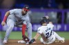 Washington Nationals second baseman Luis García Jr., left, tags out Miami Marlins' Connor Norby (24) before throwing to first to put out Jake Burger for the double play, during the first inning of a baseball game, Tuesday, Sept. 3, 2024, in Miami. (AP Photo/Wilfredo Lee)