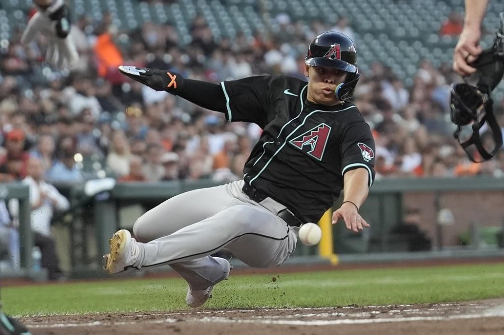 Arizona Diamondbacks' Geraldo Perdomo slides home to score against the San Francisco Giants during the second inning of a baseball game in San Francisco, Tuesday, Sept. 3, 2024. (AP Photo/Jeff Chiu)