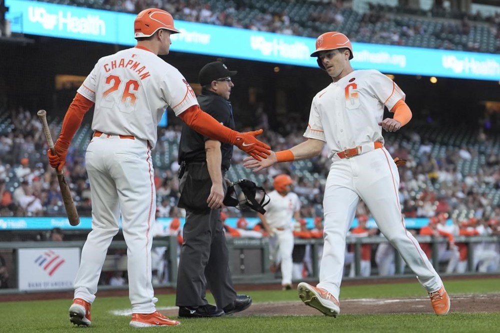 San Francisco Giants' Mike Yastrzemski, right, is congratulated by Matt Chapman (26) after scoring against the Arizona Diamondbacks during the first inning of a baseball game in San Francisco, Tuesday, Sept. 3, 2024. (AP Photo/Jeff Chiu)