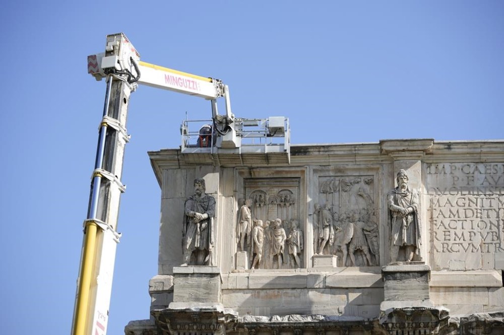 Workers on site with cranes gather up fragments and secure broken areas of the 315 A.D Arch of Constantine, near the Colosseum, in Rome, Wednesday, Sept. 4, 2024, after lightning struck it during a storm Tuesday, Sept. 3, loosening fragments from the ancient Roman structure. (AP Photo/Andrew Medichini)