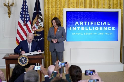 FILE - President Joe Biden signs an executive on artificial intelligence in the East Room of the White House, Oct. 30, 2023, in Washington. Vice President Kamala Harris looks on at right. (AP Photo/Evan Vucci, File)