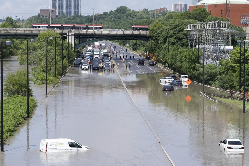 Cars are partially submerged in flood waters in the Don Valley following heavy rain in Toronto, on Tuesday, July 16 2024. The Insurance Bureau of Canada says this summer saw a record number of insurance claims driven by four major weather events and natural disasters. THE CANADIAN PRESS/Arlyn McAdorey