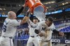 Miami Marlins first baseman Jake Burger, left, and designated hitter Jonah Bride, rear, douse shortstop Xavier Edwards after the Marlins beat the Washington Nationals 4-3, in 10 innings of a baseball game, Wednesday, Sept. 4, 2024, in Miami. (AP Photo/Wilfredo Lee)