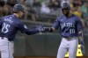 Seattle Mariners outfielder Victor Robles (10) is congratulated by Dylan Moore (25) after scoring on a single by Mitch Garver during the fourth inning of a baseball game against the Oakland Athletics in Oakland, Calif., Wednesday, Sept. 4, 2024. (AP Photo/Jed Jacobsohn)