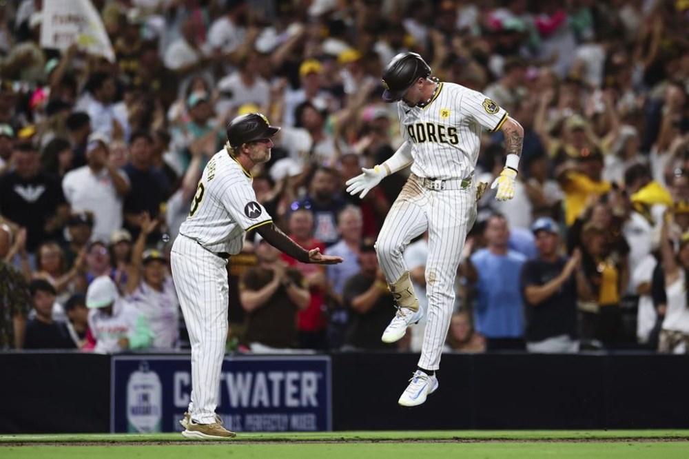 San Diego Padres' Jackson Merrill, right, celebrates with third base coach Tim Leiper as he runs the bases after hitting a three-run home run against the Detroit Tigers in the fourth inning of a baseball game Wednesday, Sept. 4, 2024, in San Diego. (AP Photo/Derrick Tuskan)