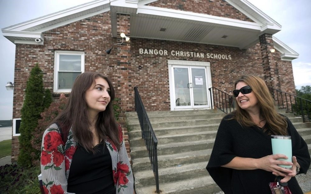 FILE - Olivia Carson, then a 15-year-old sophomore, of Glenburn, Maine, left, stands with her mother Amy outside the Crosspoint Church-affiliated Bangor Christian Schools on August 28, 2018 in Bangor, Maine. (Gabor Degre/The Bangor Daily News via AP, File)