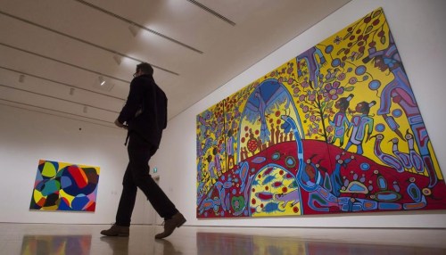A reporter walks past 'Androgyny' by Norval Morrisseau (right) during a media tour of the Canadian and Indigenous Art: 1968 to Present at the National Gallery of Canada's contemporary art galleries Tuesday May 2, 2017 in Ottawa. THE CANADIAN PRESS/Adrian Wyld