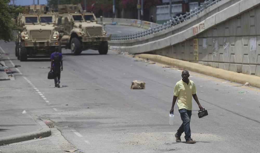 A man walks near armored vehicles of Kenyan police officers part of a UN-backed multinational in Port-au-Prince, Haiti, Wednesday, Sept. 4, 2024. (AP Photo/Odelyn Joseph)