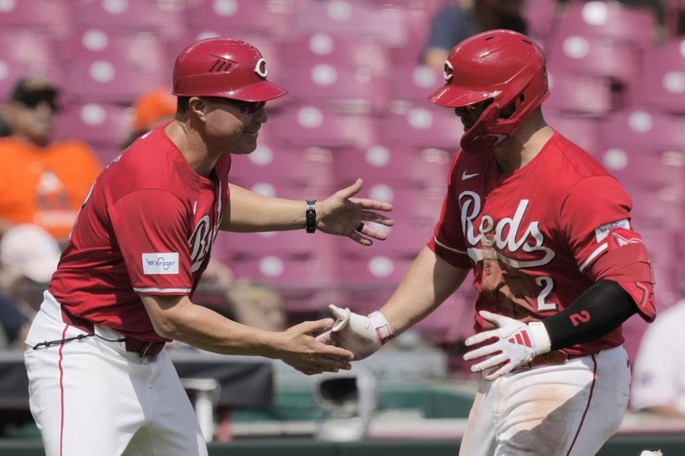 Cincinnati Reds' Ty France, right, celebrates with third base coach J.R. House as he rounds the bases after hitting a home run during the seventh inning of a baseball game against the Houston Astros, Thursday, Sept. 5, 2024, in Cincinnati. (AP Photo/Carolyn Kaster)