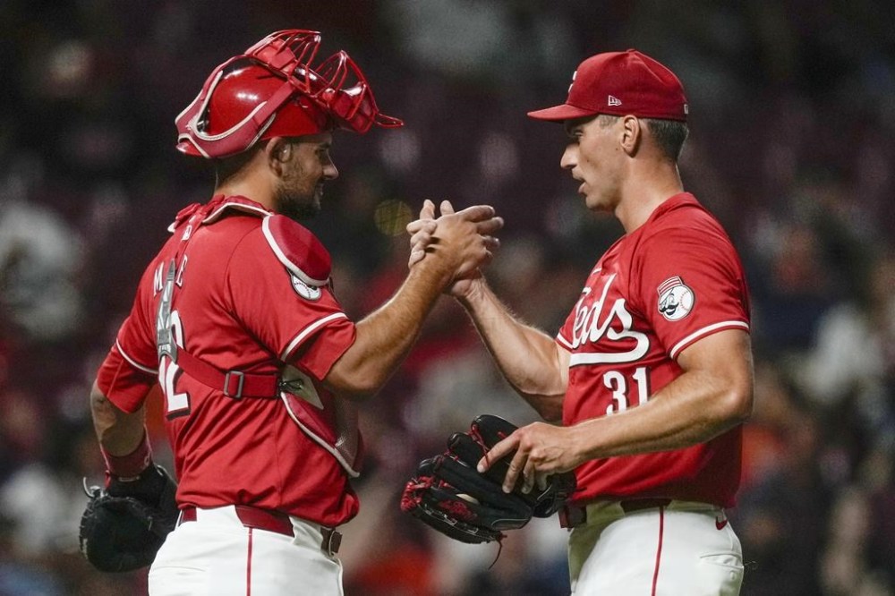 Cincinnati Reds pitcher Brent Suter (31) and catcher Luke Maile (22) celebrate after winning a baseball game against the Houston Astros, ,Wednesday, Sept. 4, 2024, in Cincinnati. (AP Photo/Carolyn Kaster)