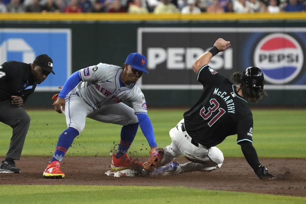 Arizona Diamondbacks' Jake McCarthy (31) slides into second base safely under the tag by New York Mets shortstop Francisco Lindor in the third inning of a baseball game, Wednesday, Aug. 28, 2024, in Phoenix. (AP Photo/Rick Scuteri)