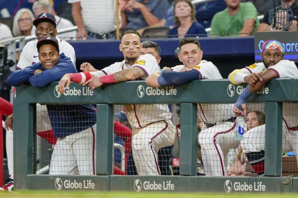 Atlanta Braves outfielder Jorge Soler, far left, pitcher Raisel Iglesias, left with blue sweatshirt, shortstop Orlando Arcia center left, third baseman Gio Urshela, center right, and outfielder Michael Harris II, right, watch Marcell Ozuna (20) at bat in the ninth inning of a baseball game against the Colorado Rockies, Thursday, Sept. 5, 2024, in Atlanta. (AP Photo/Jason Allen)