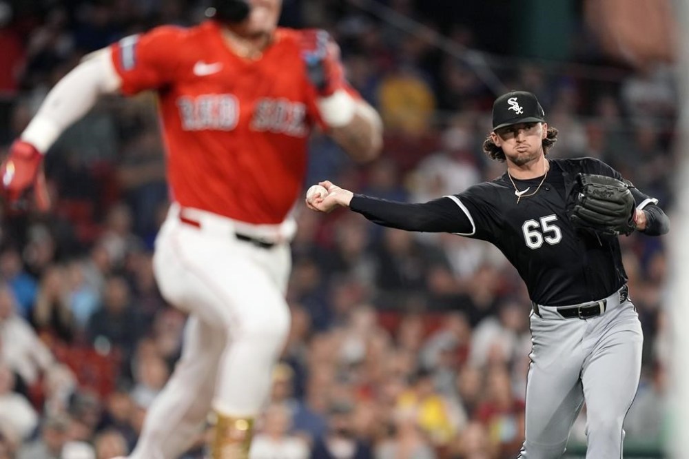 Chicago White Sox starting pitcher Davis Martin (65) throws to first base on a groundout by Boston Red Sox's Jarren Duran, left, during the third inning of a baseball game, Friday, Sept. 6, 2024, in Boston. (AP Photo/Michael Dwyer)