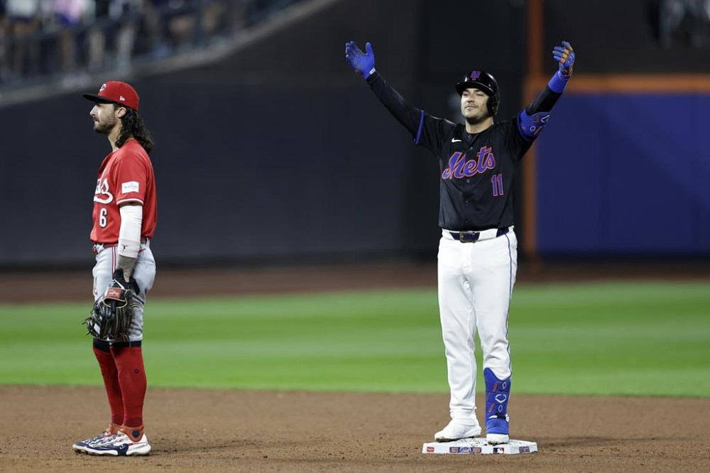 New York Mets' Jose Iglesias (11) reacts behind Cincinnati Reds second baseman Jonathan India (6) after hitting a run scoring single and then advancing to second base during the sixth inning of a baseball game, Friday, Sept. 6, 2024, in New York. (AP Photo/Adam Hunger)