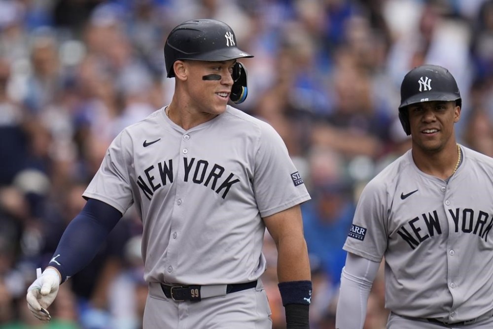 New York Yankees' Aaron Judge, left, and Juan Soto return to the dugout after they both scored on a single by Austin Wells during the third inning of a baseball game against the Chicago Cubs, Friday, Sept. 6, 2024, in Chicago. (AP Photo/Erin Hooley)