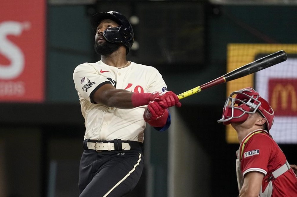 Texas Rangers' Sandro Fabian follows through on a fly out to right, as Los Angeles Angels catcher Logan O'Hoppe looks on in the second inning of a baseball game, Friday, Sept. 6, 2024, in Arlington, Texas. (AP Photo/Tony Gutierrez)