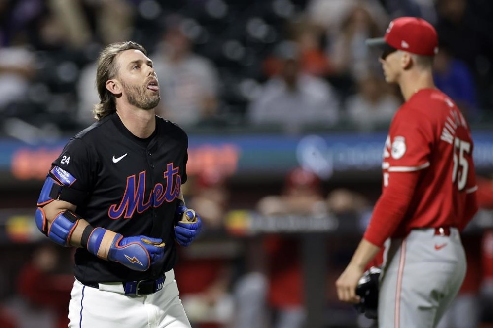 New York Mets' Jeff McNeil, left, reacts after being hit by a pitch from Cincinnati Reds' Brandon Williamson during the fifth inning of a baseball game Friday, Sept. 6, 2024, in New York. (AP Photo/Adam Hunger)
