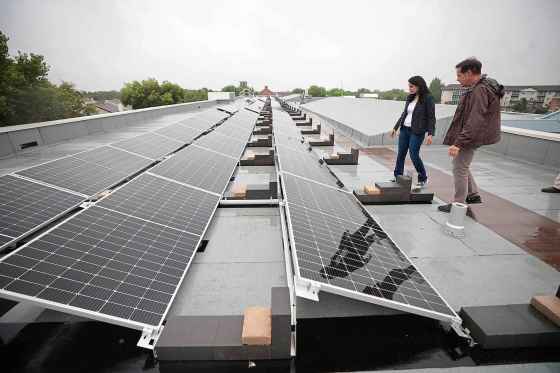 Former principal Alain Michalik (right) and Amarbeer Bhandari, director of facilities, maintenance and transportation check out the solar panels. (Ruth Bonneville/Free Press)