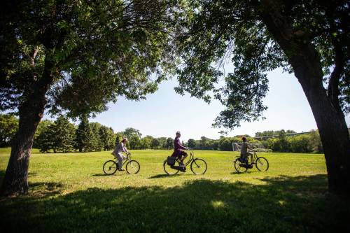 MIKAELA MACKENZIE / FREE PRESS 	 Brenda McLean (left), Eric Rae (centre, tour guide), and Daina Leitold ride bikes as part of Bike and Circuses media call at Whittier Park on Thursday, Aug. 1, 2024. For Thandi story.
                                Photos by MIKAELA MACKENZIE / FREE PRESS
                                From left: Brenda McLean, tour guide Eric Rae and Daina Leitold at Whittier Park