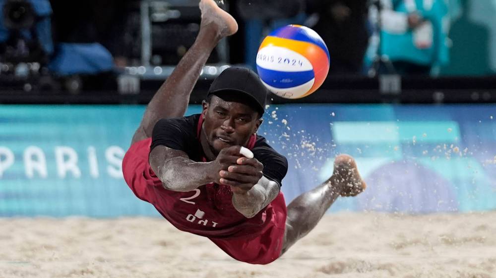 Robert F. Bukaty / The Associated Press
Qatar’s Ahmed Tijan dives to keep the ball in play during a beach volleyball match against Italy last Saturday in Paris.