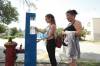 Ruth Bonneville / Free Press
                                Madison and her mom Priscilla stop to fill up a water bottle at one of eight hydration stations the city has installed in recent years. The stations are part of the city’s response to extreme heat concerns.