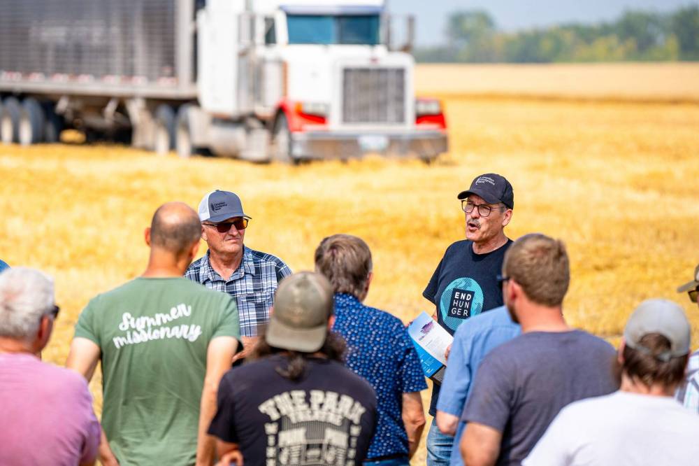 NIC ADAM / FREE PRESS
Foodgrains regional representative Gordon Janzen (centre right) and Landmark growing project coordinator Randy Plett (centre left) speak to volunteers at the growing project’s field outside Landmark, Tuesday.