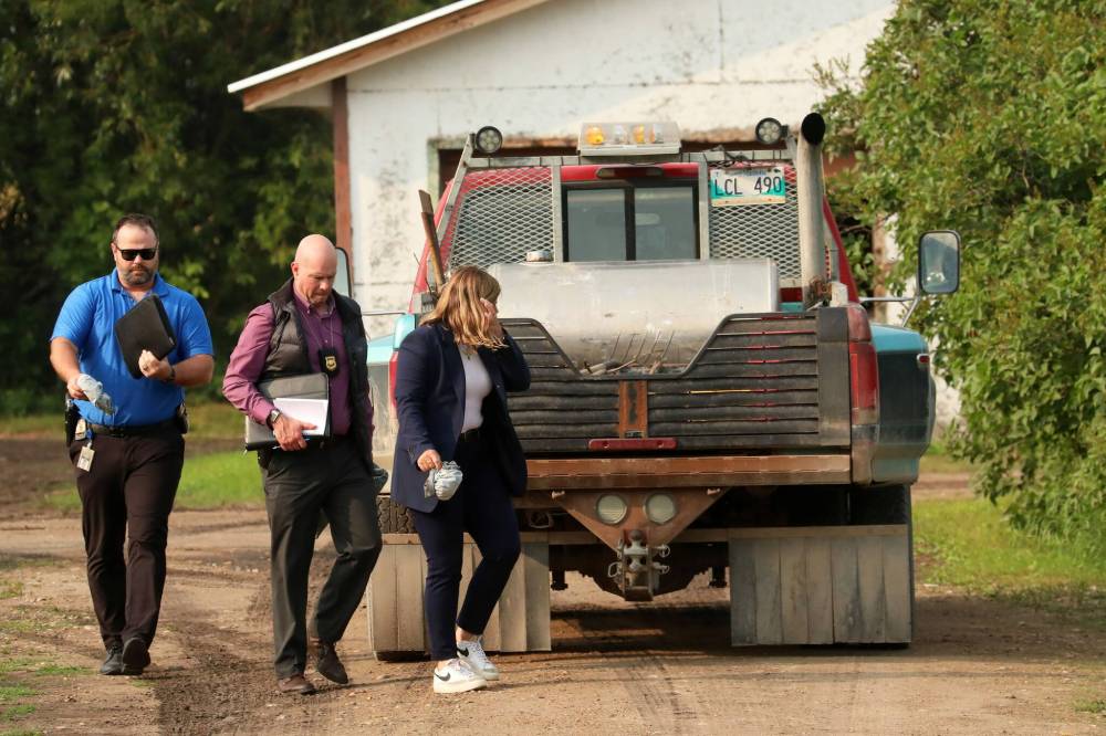 TIM SMITH / BRANDON SUN FILES
                                RCMP officers at the scene of the triple homicide southeast of McCreary on Friday evening.