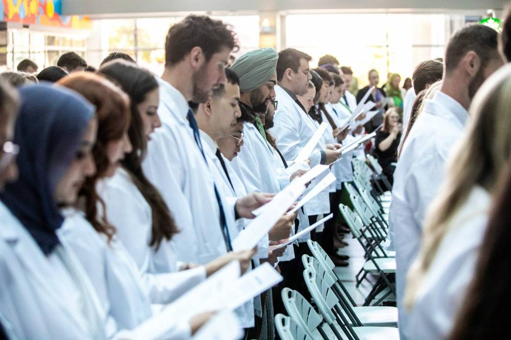 MIKAELA MACKENZIE / FREE PRESS
The newest University of Manitoba medical class recites the physicians’ pledge in a ceremony at the Max Rady College of Medicine on Wednesday.