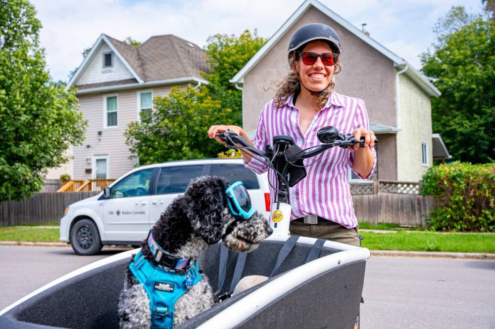 NIC ADAM / FREE PRESS
Cyclist Julia Schroeder rides her cargo bike along Annabella St. Wednesday with her dog Willow. She will be participating in Thursday’s group ride.