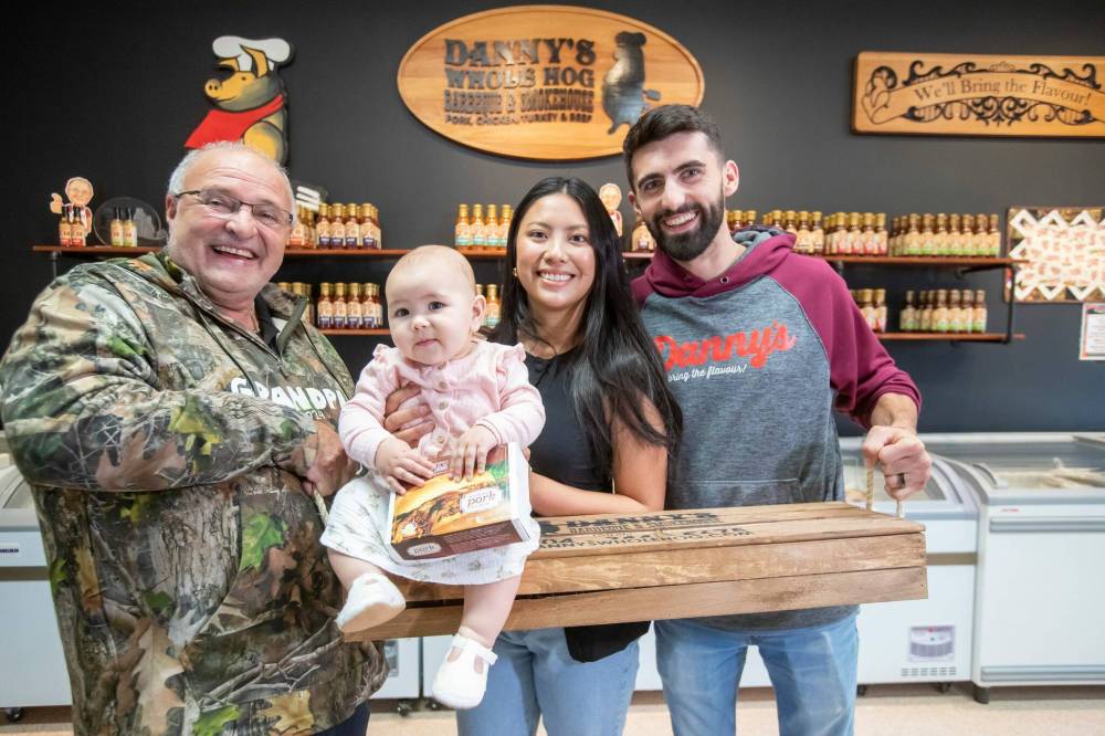 Danny Kleinsasser, 62, (left) of Danny's Whole Hog Barbecue & Smokehouse with his son Isaiah, daughter-in-law Kaeziah and granddaughter Ariyah. (Brook Jones / Free Press)