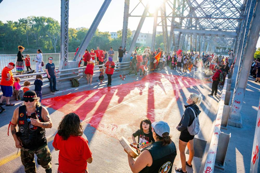 NIC ADAM / FREE PRESS
Family members held a prayer and offered tobacco to the water before painting a red dress symbol with the words “Justice for Doris” across both lanes of the bridge.