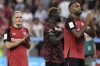 Leverkusen's Florian Wirtz (l-r), Victor Boniface and Jonathan Tah stand on the pitch after the Bundesliga soccer match between Bayer Leverkusen and RB Leipzig at the BayArena, in Leverkusen, Germany, Saturday, Aug. 31, 2024. (Federico Gambarini/dpa via AP)